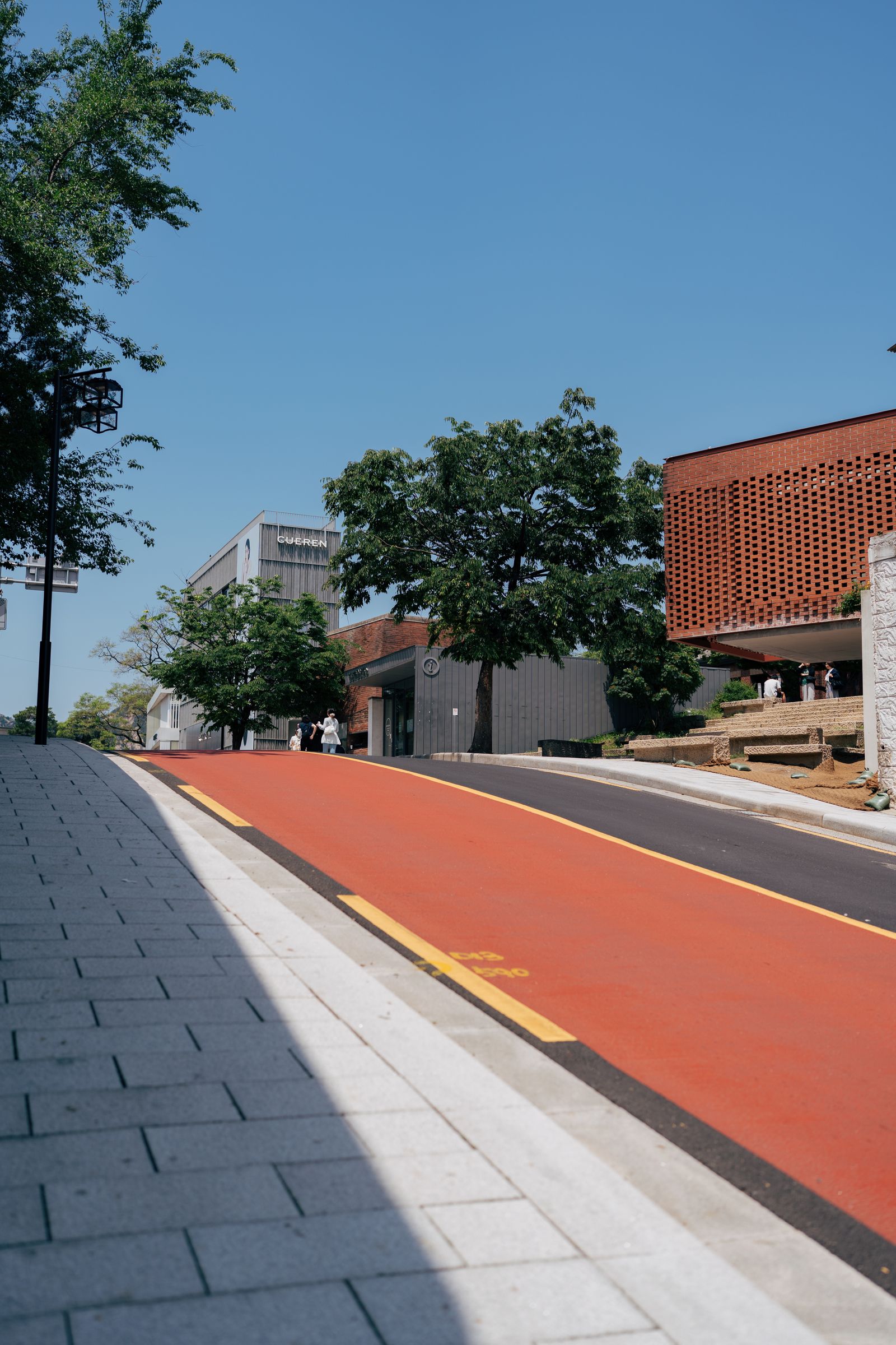 Sunlit Seoul cultural neighbourhood with a blue sky and pedestrian path