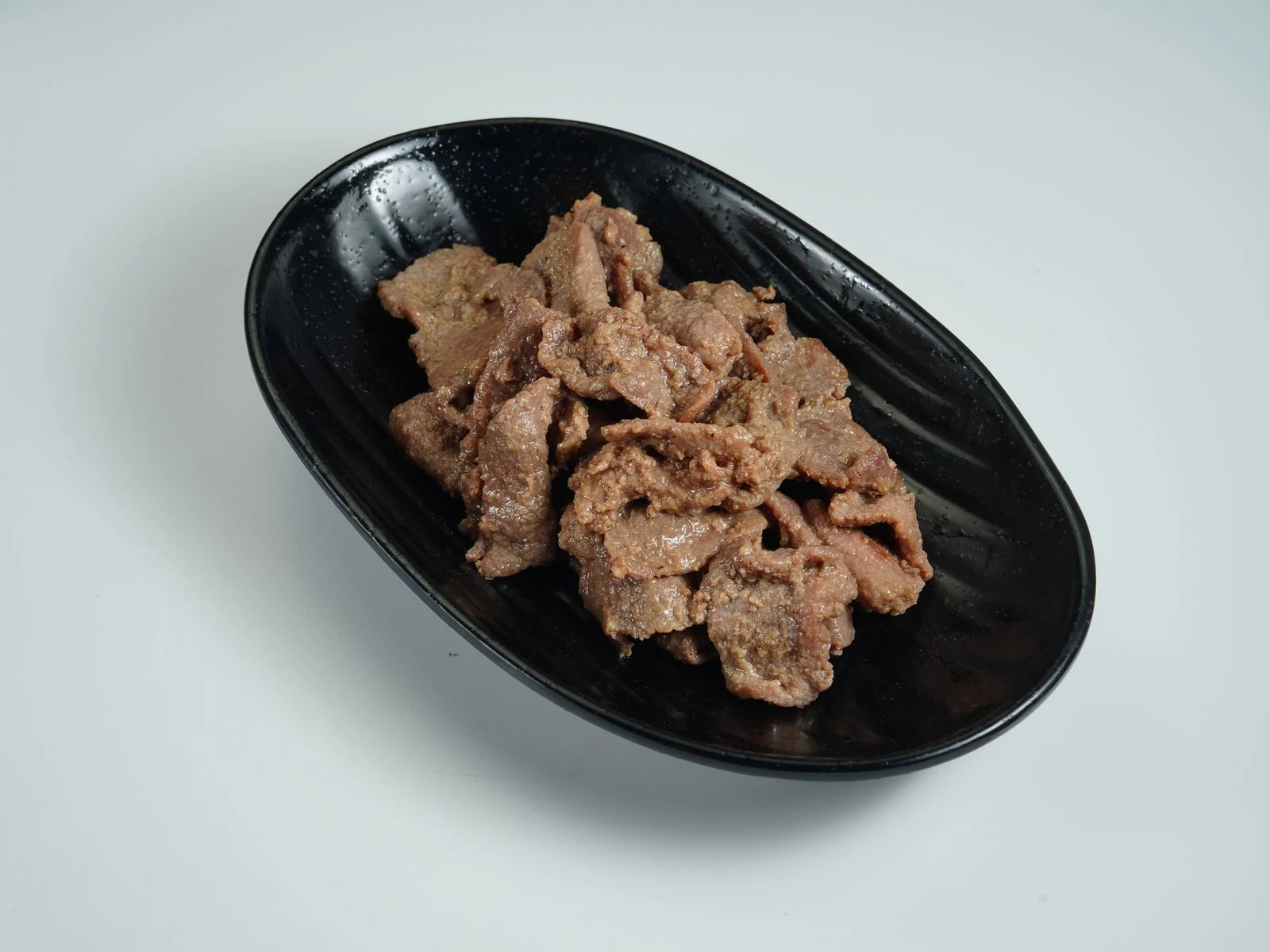 Marinated beef served in a dark bowl. Ingredients and preparation vary by restaurant.