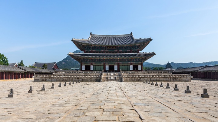 Front view of Geunjeongjeon hall at Gyeongbokgung Palace under a blue sky